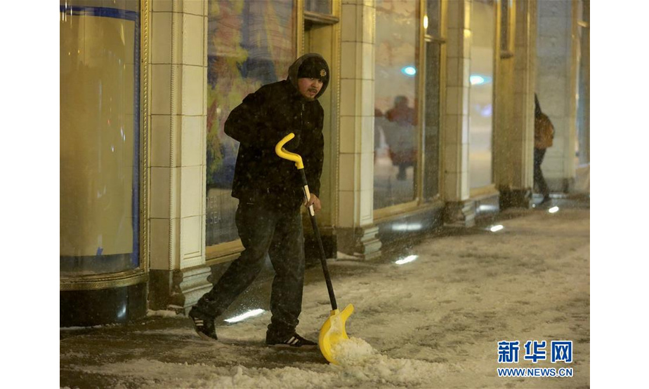 1月17日，在美国芝加哥，一名男子在街头除雪。 美国芝加哥当日遭暴风雪袭击，地面积雪严重，影响交通和出行。 新华社记者 汪平 摄