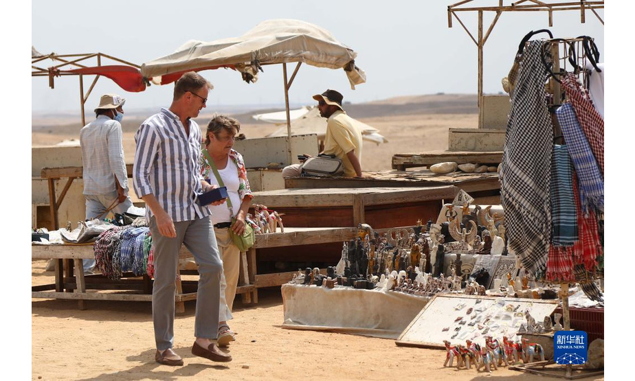 9月27日，游客在埃及吉萨金字塔群景区内的纪念品摊位前游览。

　　每年的9月27日是世界旅游日。新冠疫情导致埃及旅游业受到冲击，游客数量下降明显。但随着埃及国内新冠疫苗的持续接种，各类防疫措施的执行以及旅游资源的宣介和推广，埃及游客数量近来逐渐增多。吉萨金字塔群游客数量现已恢复至疫情前游客数量的一半以上。

　　新华社发（艾哈迈德·戈马摄）