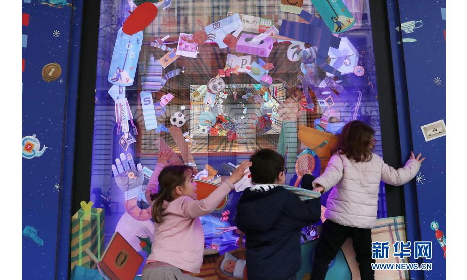 11月22日，孩子们在法国巴黎老佛爷百货商店的圣诞橱窗前嬉戏。新华社记者 高静 摄