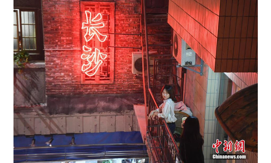 6月13日，一位食客正在文和友老长沙龙虾馆内拍照留念。该餐厅拥有近5000平方米的超大空间，融合了老长沙的人文情怀和特色餐饮的新创意，完全还原了上世纪八十年代老长沙的风貌，受到了众多都市人的热捧。中新社记者 杨华峰 摄