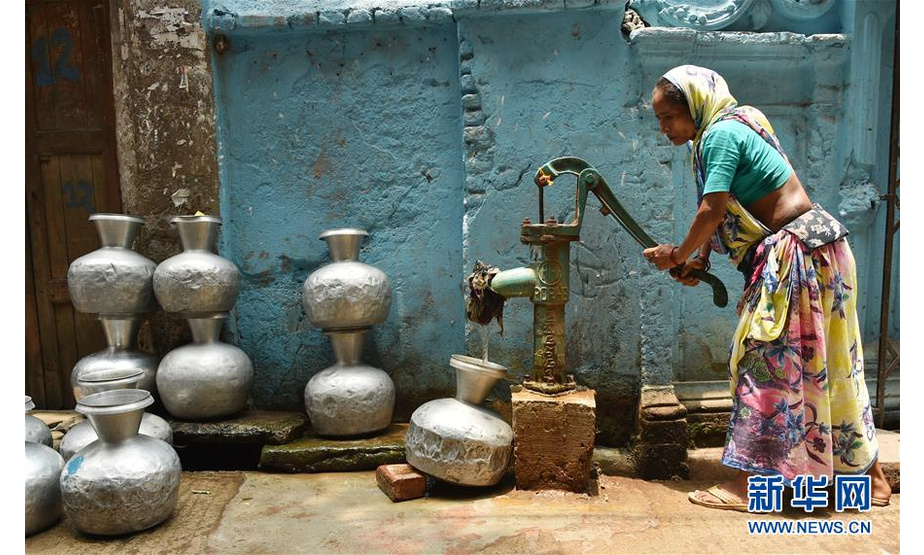 5月20日，在孟加拉国首都达卡，一名女子在管井处取水。由于近一个月的热浪侵袭以及几乎没有降雨，孟加拉国首都达卡老城区市民面临供水危机。新华社发