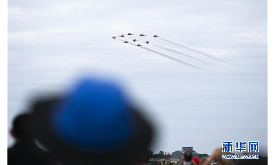 7月22日，人们在英国法恩伯勒航展上观看英国皇家空军“红箭”飞行表演队的特技飞行表演。新华社记者韩岩摄