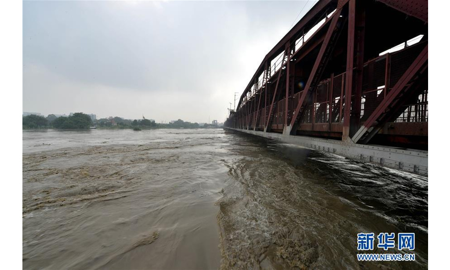这是8月20日在印度新德里拍摄的水位上涨的亚穆纳河。连日来，暴雨导致印度亚穆纳河水位上涨，新德里市政府要求生活在低洼地带的人们转移到安全地区。新华社发（帕塔·萨卡尔 摄）