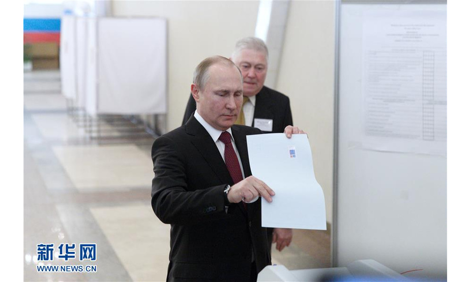 3月18日，俄罗斯现任总统普京（前）在莫斯科的一处投票站投票。截至莫斯科时间18日21时，在俄罗斯选举机构统计的全俄21.33%的选票中，现任总统普京以71.97%的得票率在总统选举中领先。新华社记者 白雪骐 摄