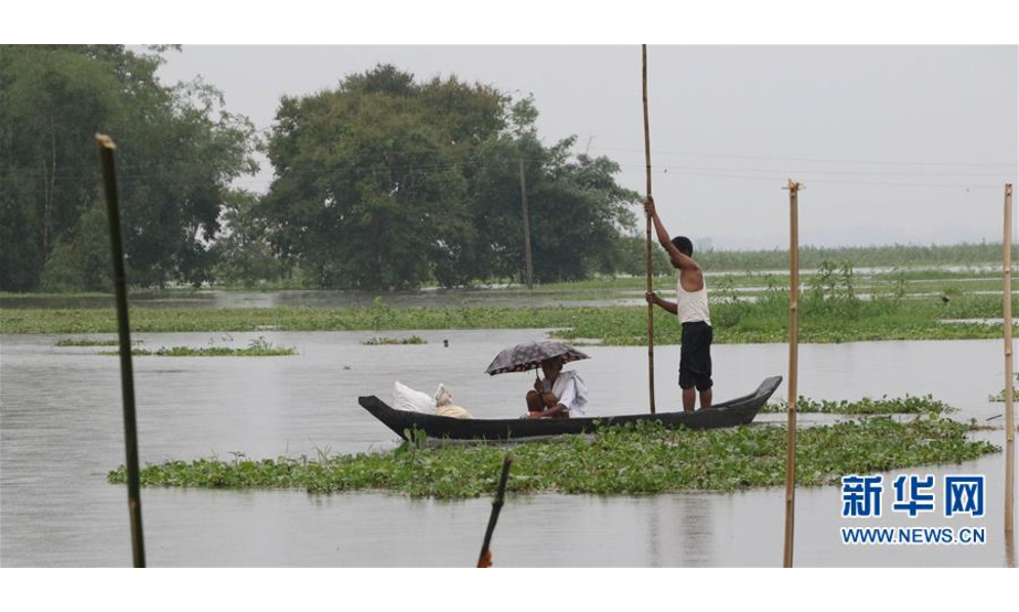 7月15日，在印度东北部阿萨姆邦焦尔哈德，当地居民划船前行。据印度媒体15日报道，近日持续降雨导致印度多地发生洪灾，目前已造成近50人死亡，440多万人受灾。印度气象部门15日预测，未来两三天，印度东北部仍有较大降雨。新华社发
