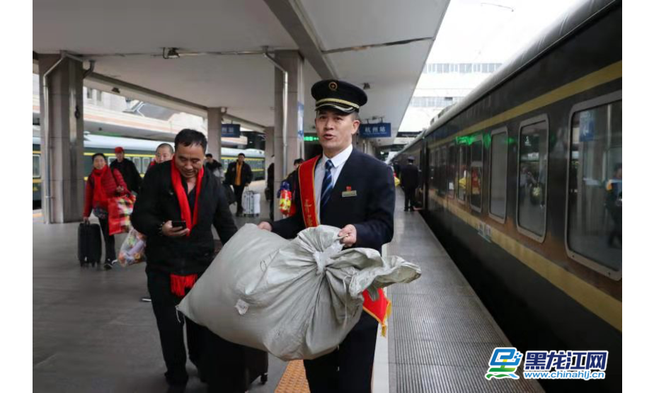 黑龙江网（王双 记者 石启立） 1月19日，中国铁路哈尔滨局齐齐哈尔客运段团委组织杭州车队休班的青年志愿者，在k48次列车上，为集中返乡的进城务工人员打造温馨舒适的旅途。车厢内除了为他们提供细心周到的服务，还精心准备了互动节目，送福袋、送春联、送祝福，让他们提前感受回家的温暖。 图为齐齐哈尔客运段青年志愿者帮助农民工拿行李。