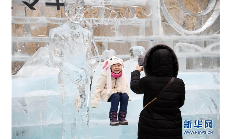 1月1日，一名小女孩在哈尔滨中央大街的冰雕前留影。

　　当日是2019年新年第一天，市民和游客在哈尔滨享受赏冰玩雪带来的快乐。

　　新华社记者王建威 摄