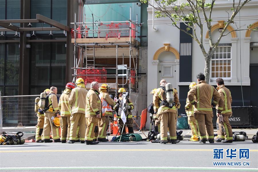 10月22日，在新西兰奥克兰市中心，消防员在火灾现场集结。 新西兰奥克兰市中心正在兴建的天空城会展中心顶部22日突然发生火灾。警方发言人说，火灾已造成至少1人重伤、1人失踪。 新华社发（许立明摄）