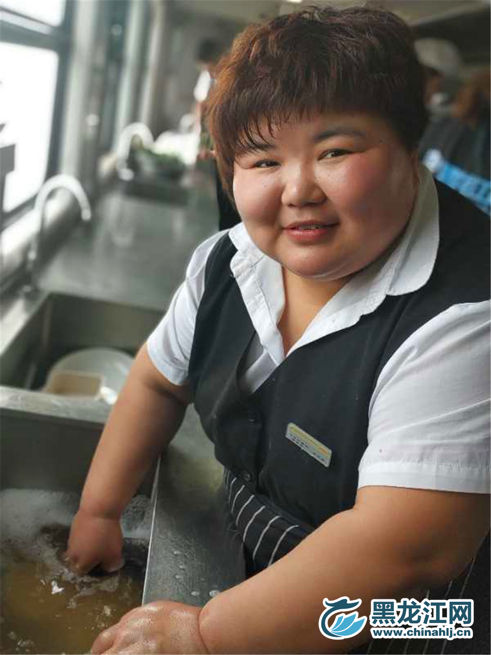 将手伸进藏水池，冲向镜头面带微笑。  宋菲 摄