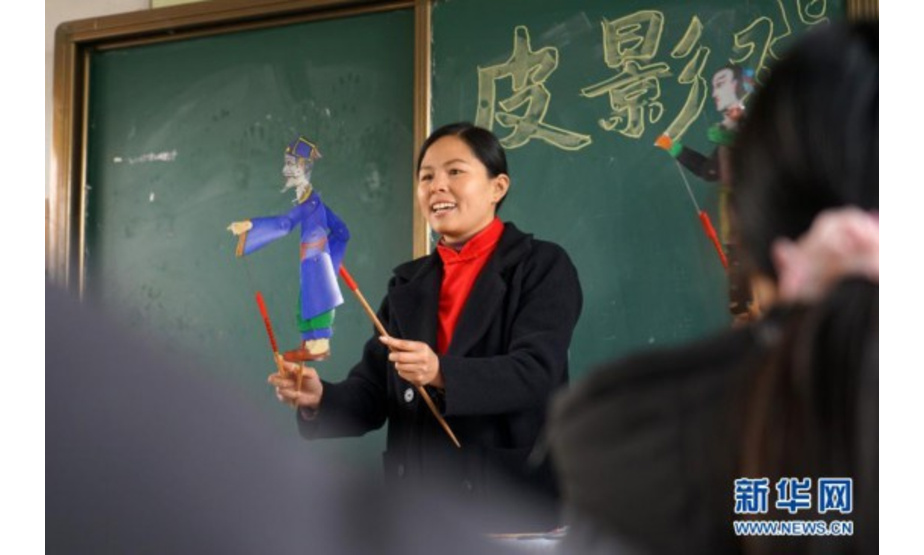11月24日，皮影戏艺人在河北省沙河市西油村小学为学生讲解皮影戏道具使用方法。