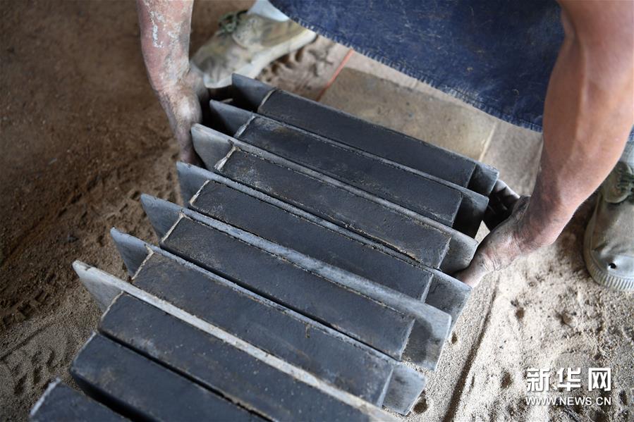8月15日，在泾县茂林花砖厂，工人在摆放制作的砖坯。 花砖是安徽省泾县茂林镇特有的一种古建装饰材料，主要用于门、墙、窗户的装饰。上品花砖呈青白色，不仅花纹清晰、图案雅致，而且具有手感轻柔、不沾灰的特点。明清时期，花砖开始普遍运用于茂林当地民宅中。然而，花砖制作工艺复杂，成本高，加上花砖艺人因躲避战乱流落他乡，花砖制作工艺一度失传。20世纪90年代，茂林人开始重新挖掘花砖制作工艺，逐渐恢复了花砖的生产。如今，花砖制作工艺包括取土、制坯、烧制、水磨等12道大的工序。2014年，花砖制作技艺被列为安徽省省级非物质文化遗产。 新华社记者 刘军喜 摄