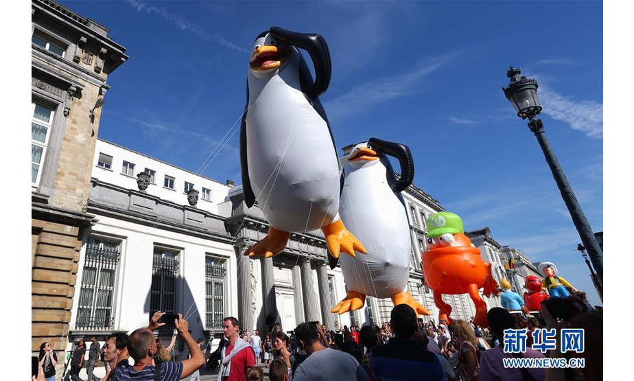 9月15日，人们在比利时首都布鲁塞尔观看卡通气球大巡游。 当日，布鲁塞尔举行第十届布鲁塞尔漫画节卡通气球大巡游，形态各异的卡通气球从街头巷尾穿行而过，吸引大批市民和游客。 新华社记者 郑焕松 摄
