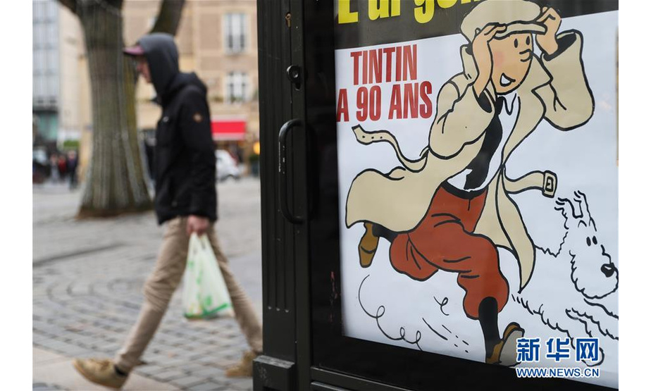 1月10日，在比利时布鲁塞尔街头，一名行人从一幅庆祝《丁丁历险记》诞生90周年的海报旁走过。 

　　当日是比利时经典连环画《丁丁历险记》诞生90周年。《丁丁历险记》由比利时漫画家埃尔热创作，自1929年1月10日起在比利时报纸上开始双周连载。连环画中的丁丁生活在20世纪的欧洲，以记者的身份奔走于世界各地，明察暗访、匡扶正义。该作品备受全世界人们的喜爱，先后被翻译成70多种文字，全球销量超过3亿册。

　　新华社记者 郑焕松 摄