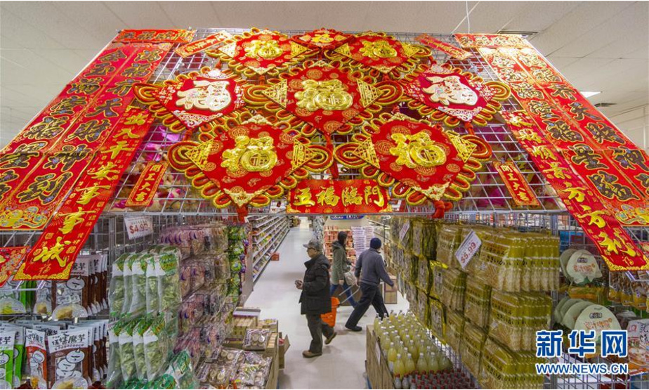 2月21日，在加拿大多伦多，顾客在超市购物。为庆祝中国农历狗年春节，多伦多的许多商店、超市及城市广场推出以春节为主题的装饰及宣传，过年气氛浓郁。 新华社发（邹峥摄）