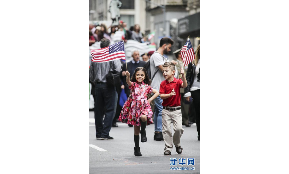 10月8日，在美国纽约曼哈顿第五大道，两名儿童参加哥伦布日游行。  新华社记者王迎摄