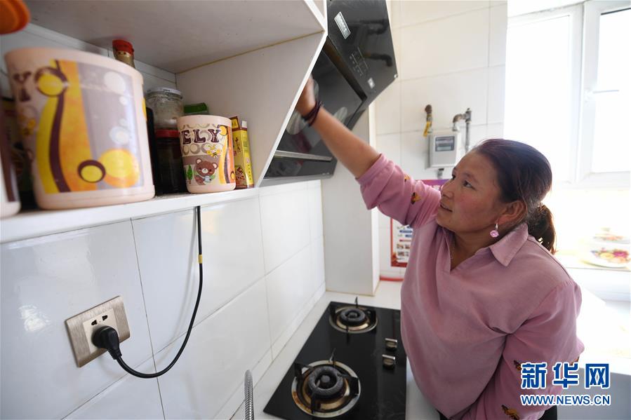 在新疆阿勒泰地区青河县阿格达拉镇，33岁的库丽森·加那特拜在新家做家务（8月9日摄）。新华社记者 沙达提 摄