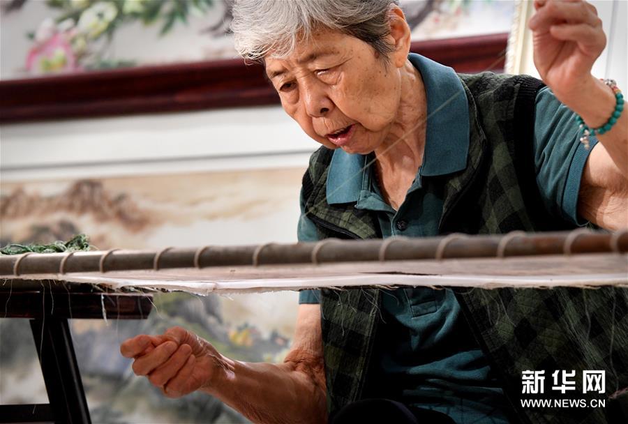 在开封市素花宋绣工艺有限公司的展示馆里，王素花在刺绣（7月30日摄）。“一针一线绣人生，一心一意做好人。”在河南开封市素花宋绣工艺有限公司的展示馆里，85岁的王素花一边劈线一边讲述自己的故事。 王素花是国家级非物质文化遗产汴绣代表性传承人，从1957年开始从事汴绣工作至今。 汴绣早在宋代就已驰名全国，多以历史名画为题材。为了发展汴绣技艺，王素花多方搜集老绣片和早期绣制的生活用品，在整理挖掘传统宋绣工艺的基础上，和工友们创新了反戗绣、拉链绣、蒙针绣、水纹绣、悠针绣等10余种针法，并于1959年绣制完成宋代张择端的名画《清明上河图》，成为汴绣历史上具有里程碑意义的名作。 为了更好地传承汴绣技艺，1990年，从开封汴绣厂退休的王素花，创办了“开封市素花宋绣工艺有限公司”，亲自授徒。30年来，她免费培训农村贫困地区的女孩、残疾孤儿和城市下岗女工1000多人。“我活一天，就教她们一天，一定要把汴绣技艺传承下去。”王素花说。新华社记者李安摄