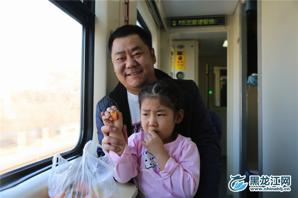 父亲捂着女儿的手微笑着面对镜头。  石启立 摄