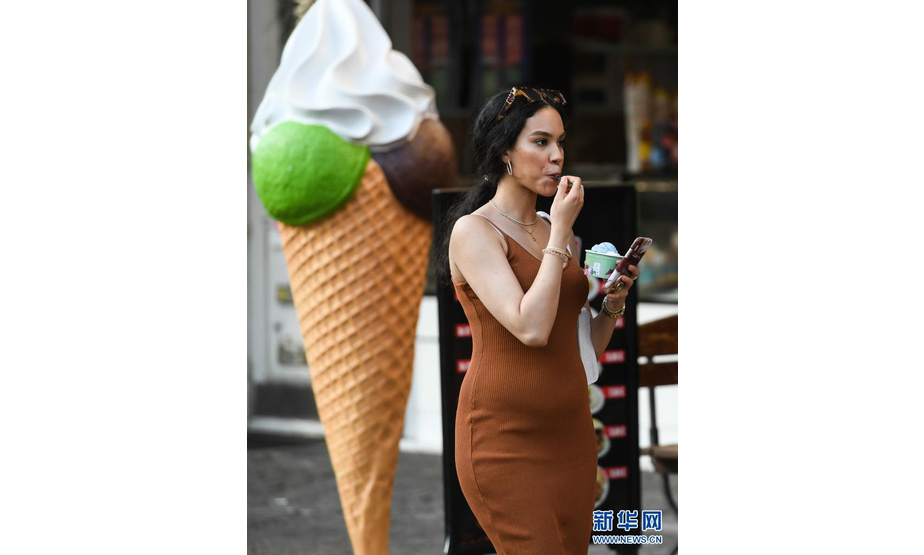 6月17日，在德国法兰克福，一名女子手拿冰激凌从街头走过。

　　当日，法兰克福遭遇高温天气，最高气温达36摄氏度。

　　新华社记者逯阳摄