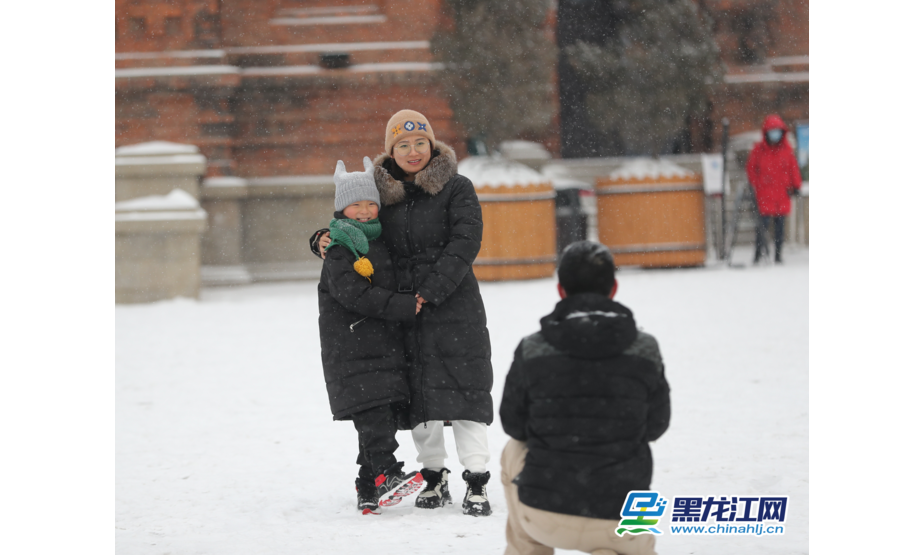 2月11日，游客在哈尔滨市建筑艺术广场前拍照留念。