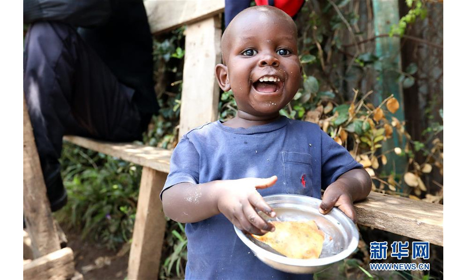 9月1日，在肯尼亚内罗毕的一个街边摊位，一名儿童品尝萨摩萨。萨摩萨是一种三角形的油酥点心，由薄面皮包裹豆类、蔬菜及牛羊肉馅后，下锅油炸而成。作为肯尼亚及东非地区的传统面食，它经常出现在当地民众的食谱和餐桌上。如今，肯尼亚的部分中餐厅也开始制作萨摩萨，以满足顾客的需求。新华社记者王腾摄