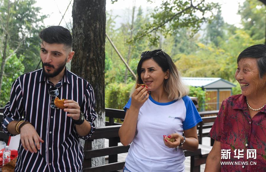 2019年9月11日，浙江省长兴县小浦镇举办“中秋月圆喜团圆，移风易俗迎中秋”乡村传统民俗体验活动，邀请在长兴县工作的外国友人们一起与当地村民做月饼、唱京剧，感受中国传统特色文化，在浓浓的文化氛围中迎接中秋节的到来。图为9月11日，外国友人在品尝手工月饼。 新华社记者 徐昱 摄