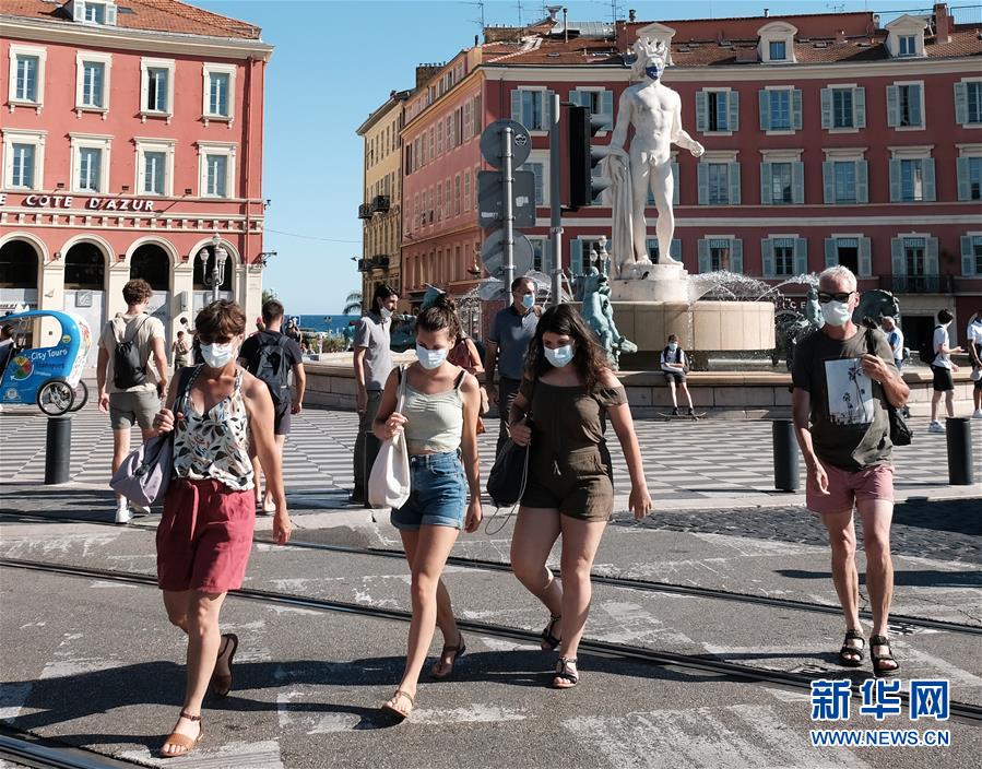 8月4日，行人佩戴口罩走在法国尼斯街头。 新华社发（塞尔日·阿乌齐摄）