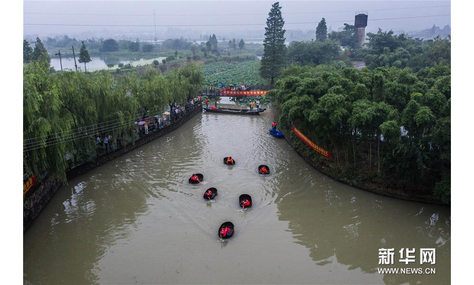 6月23日，东林镇村民在泉心村荷花池参加端午划菱桶趣味活动（无人机照片）。新华社记者 徐昱 摄