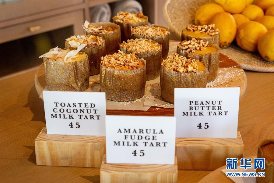9月10日，在南非约翰内斯堡，一家甜品店的橱窗里展示着不同口味的牛奶蛋挞。牛奶蛋挞是南非“糕点界”中的明星甜品。其外皮由牛奶、黄油、糖等材料混合制成，馅料则使用卡仕达酱。最后，将肉桂粉撒在成型的蛋挞上便可端上餐桌。新华社发（耶希尔摄）