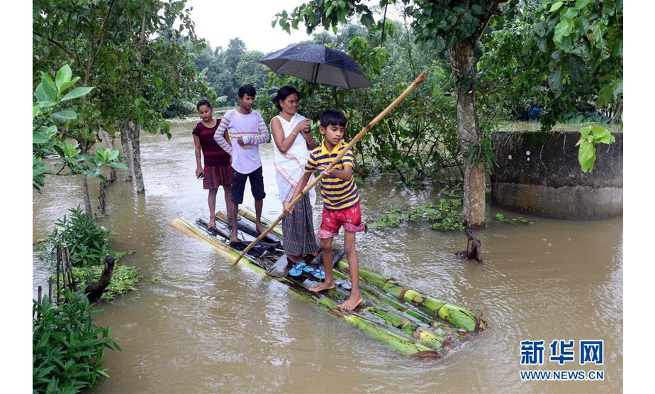 7月15日，在印度东北部阿萨姆邦焦尔哈德，当地居民划木筏前行。  新华社发
