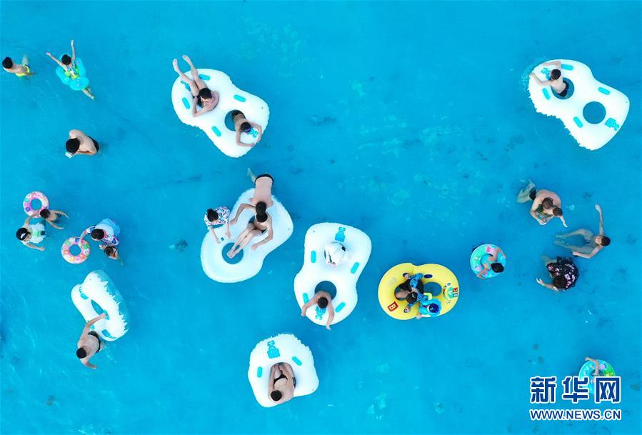 　　市民在南昌保利冰雪水世界戏水游玩（8月3日摄，无人机照片）。 近日，江西多地持续高温，不少南昌市民来到水上乐园，体验趣味水上活动，享受夏日清凉。 新华社记者 万象 摄

