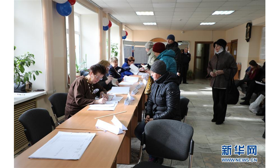 3月18日，在俄罗斯符拉迪沃斯托克的第906号投票站，工作人员向选民发放选票。位于俄罗斯领土最东端的堪察加边疆区、楚科奇自治区等地的投票站当地时间18日8时开始开放，2018年俄总统选举投票正式开始。新华社发（丹尼斯摄）