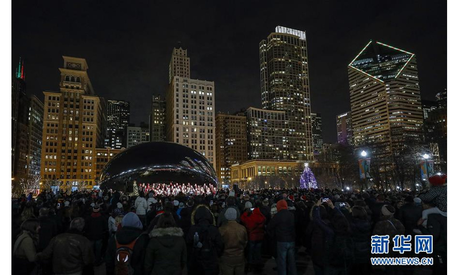 12月13日，在美国芝加哥千禧公园，人们欣赏圣诞歌曲演唱。 每年的圣诞节日季，芝加哥市政府组织当地的合唱团在千禧公园演唱圣诞歌曲，庆祝圣诞节的到来。 新华社发（乔尔·莱纳 摄）