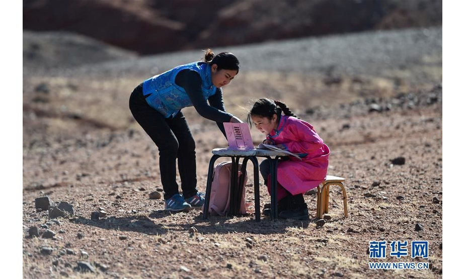 内蒙古阿拉善左旗，小学生策耿和妈妈在戈壁上寻找网络信号上网课（4月1日摄）。 新华社记者刘磊摄