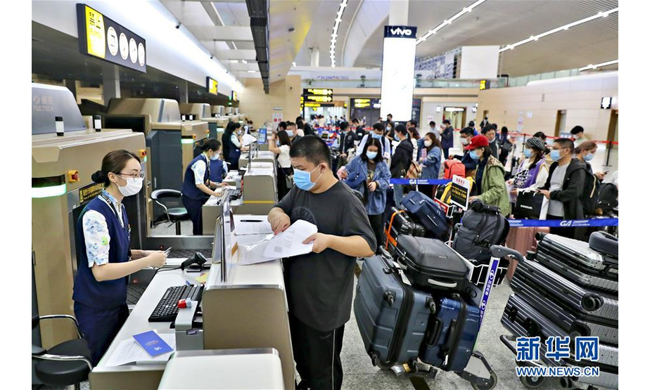 9月21日，乘坐赴英复学包机的留学生们在重庆江北国际机场航站楼内指定区域有序办理值机手续。