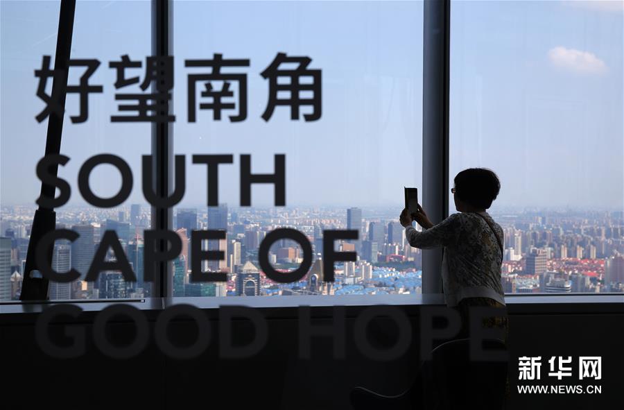 8月12日，顾客在朵云书院观景拍照。 当日，位于上海中心大厦52层的朵云书院正式开业。在离地239米的空中、2000多平方米的空间内，朵云书院售卖16000多种、6万多册中外书籍。书店集阅读、艺术展览、品牌文创、社交休闲等多功能于一体，拥有独特的空中视野和“抬头看云、低头看书”的阅读环境。 新华社记者 刘颖 摄