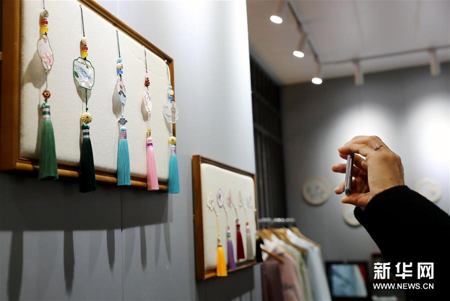 11月29日，参观者在展会现场拍摄手工制作的传统饰品。 新华社记者 刘颖 摄