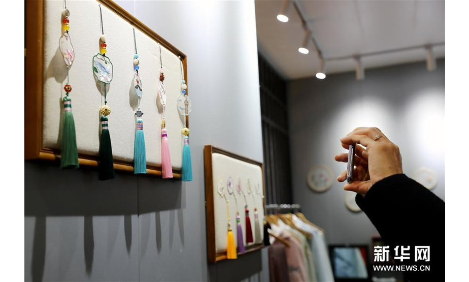 11月29日，参观者在展会现场拍摄手工制作的传统饰品。 新华社记者 刘颖 摄
