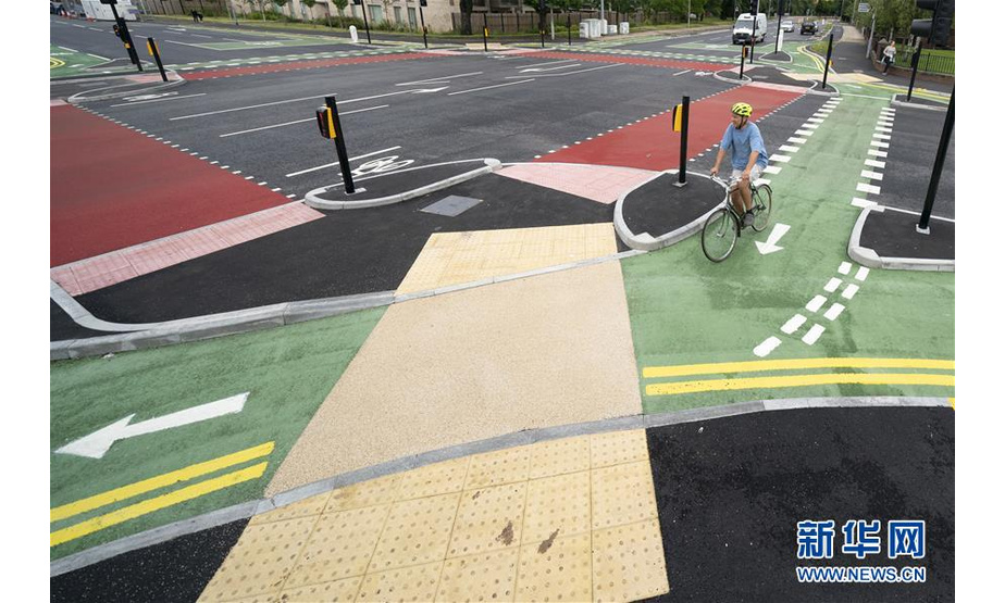 7月9日，在英国曼彻斯特，市民骑车在自行车道通行。新华社发（乔恩·休珀摄）