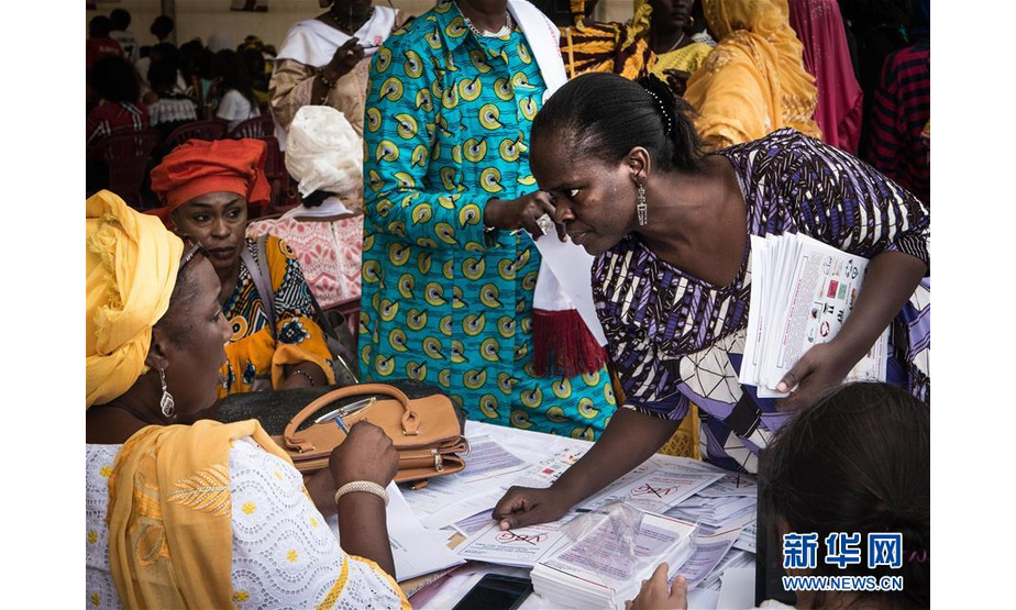 12月9日，在塞内加尔盖贾瓦伊，一名塞内加尔妇女在集会入口拿传单。

　　12月9日晚，来自塞内加尔各个城市的妇女团体在首都达喀尔附近的盖贾瓦伊举行集会，庆祝塞内加尔政府举办的“反对针对妇女的暴力活动16天”项目的结束。塞内加尔总统马基·萨勒最近表示愿意通过一项加重强奸定罪的新法律来打击针对妇女的暴力行为，这将大大延长犯罪者在监狱的刑期。

　　新华社发（路易·登加摄）