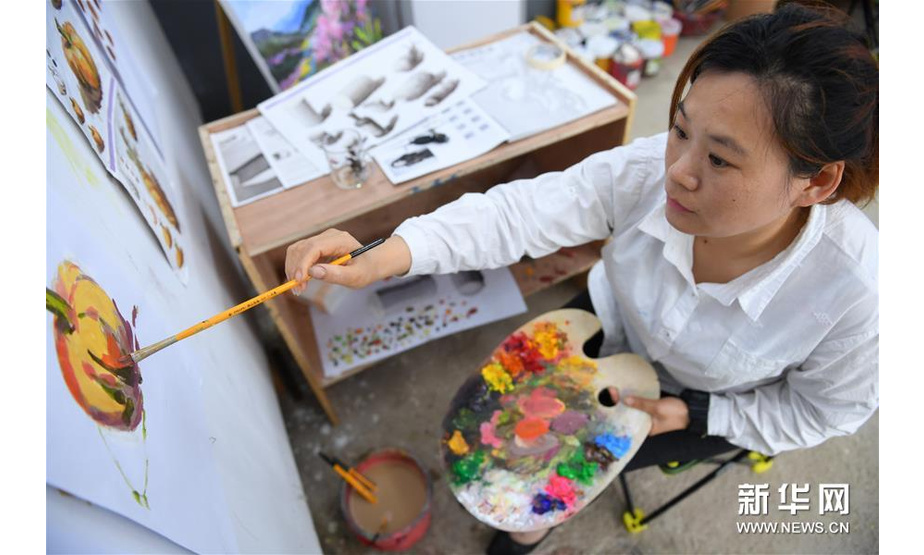 5月13日，在浏阳市小河乡乌石村，村民在绘制油画。 新华社记者 陈泽国 摄
