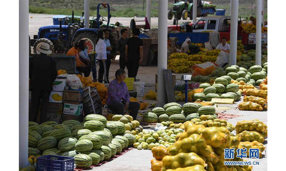 7月23日，宁夏中宁县喊叫水乡的瓜农在集市上售卖瓜果。新华社记者 冯开华 摄