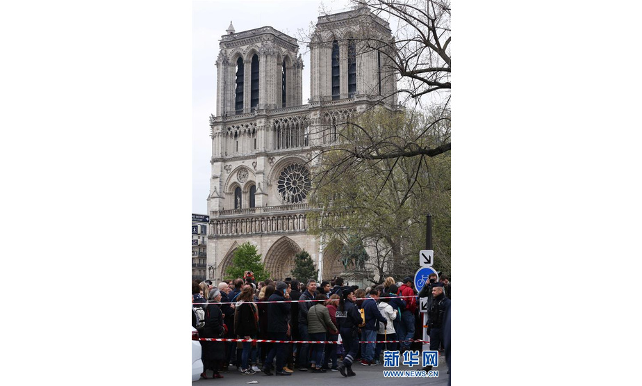 4月16日，在法国巴黎，人们聚集在“受伤”的巴黎圣母院附近。

　　当地时间15日18时左右，巴黎圣母院突发火灾，屋顶和塔尖被烧毁，但主体建筑得以保存。16日一早不断有民众来到巴黎圣母院，看望这位受伤的“老朋友”。有人带来了鲜花，放在塞纳河堤岸，更多的人站在河边默默注视不远处的圣母院。 新华社记者 高静 摄