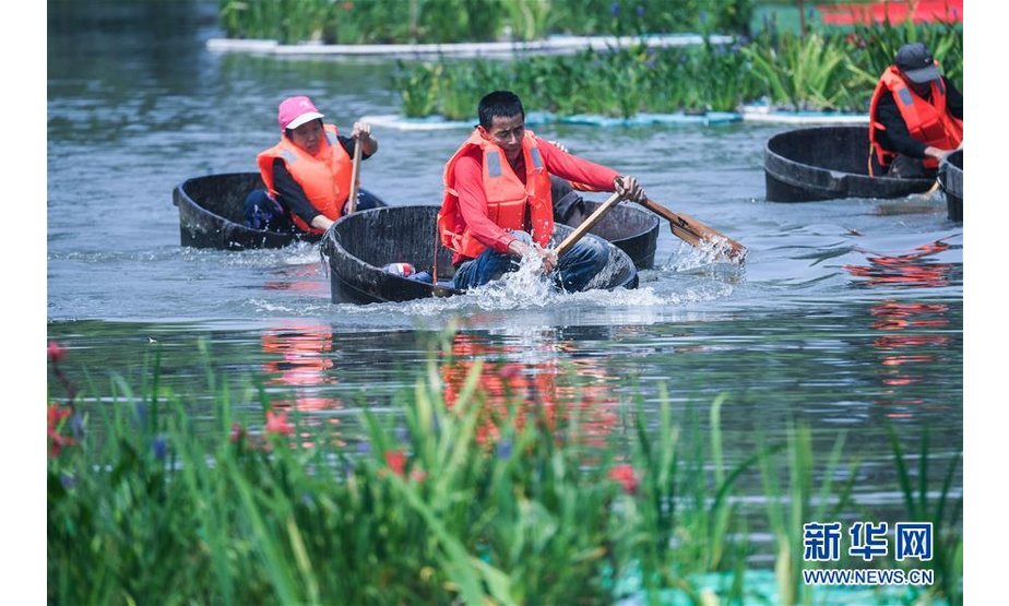 6月5日，村民们在泉益村滨水公园的河道内参加端午划菱桶趣味比赛。 新华社记者 徐昱 摄