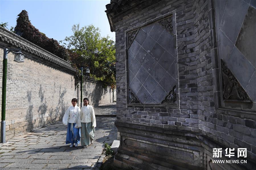 连日来，2019中国 （徐州）汉文化旅游节举行汉服嘉年华活动，为广大市民及汉服爱好者带来不一样的汉文化体验。身着各式汉服的市民演员随处可见，成为街头一道亮丽的风景。图为这是10月19日在徐州市户部山历史街区拍摄的两名汉服爱好者。 新华社记者 陶明 摄