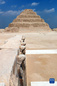 这是9月14日在埃及首都开罗以南的塞加拉地区一座左塞尔时期古墓的地上建筑拍摄的眼镜蛇雕像，以及远处的阶梯金字塔。<br/><br/>　　当日，位于埃及首都开罗以南约30公里的塞加拉地区，一座距今4000多年的古埃及第三王朝国王左塞尔时期的古墓经过近15年的修缮后正式向公众开放。该墓位于左塞尔王阶梯金字塔建筑群西南角，由地上建筑和地下墓室两大部分构成。埃及于2006年启动对该墓墓道、墓墙、墓室等建筑体的保护和修缮工作。<br/><br/>　　新华社记者 隋先凯 摄