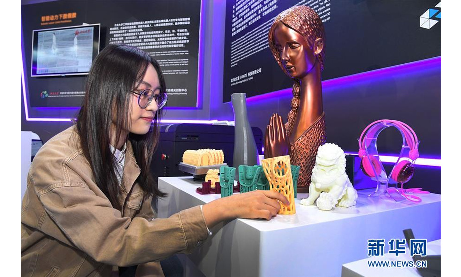 10月16日，在展览现场，观众在欣赏超高速光固化3D打印作品。新华社发（任超摄）