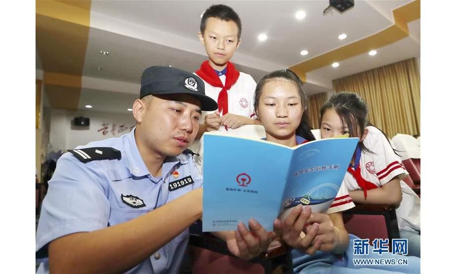 6月19日，武汉铁路公安处江岸西车站派出所民警来到武汉市京汉学校，向学生们讲解暑期出行安全知识。 新华社发（胡金力 摄）