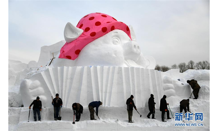 雪雕师在制作“欢乐金猪”主题雪雕（12月12日摄）。 日前，“欢乐金猪”主题雪雕在哈尔滨太阳岛雪博会园区亮相。这个为迎接农历猪年到来制作的雪雕由三只“翩翩起舞”的小猪组成，高12米、长22米。 新华社记者王建威摄