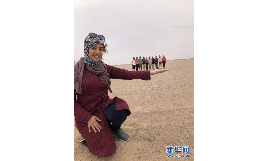 这张未标明拍摄日期的照片显示，在埃及撒哈拉沙漠里，阿斯玛（前）和中国游客合影。 新华社发
